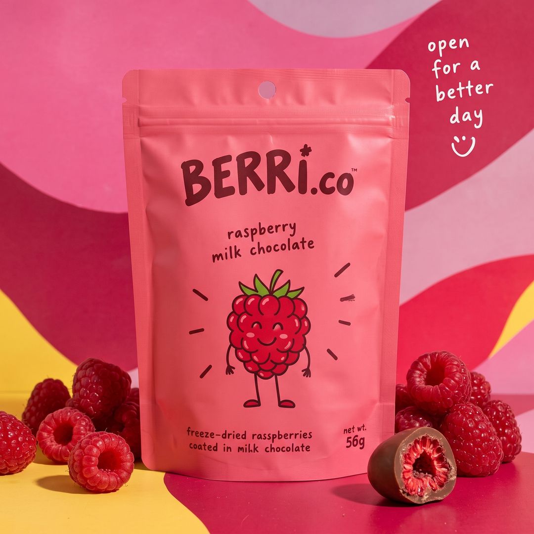 A pink pouch of raspberries in milk chocolate, with fresh raspberries around it.